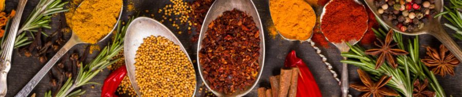 Set of various aromatic colorful spices in old vintage spoons and herbs on a dark wooden background. Ingredients for cooking. Top view